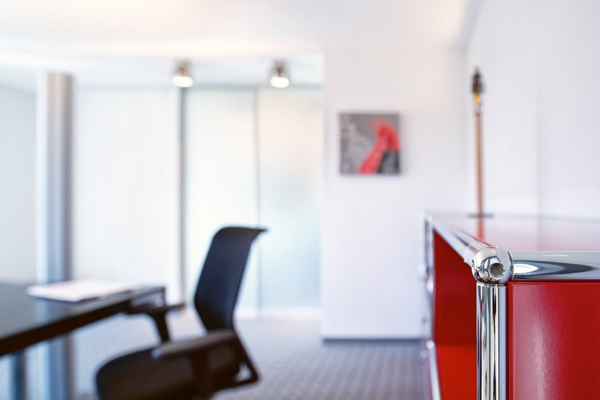 Büro mit rotem Regal und Stuhl